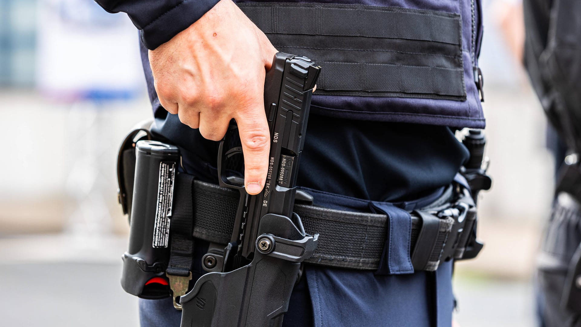 Ein Polizist hält die Hand an seiner Waffe (Symbolbild): Mit dem Schuss sollte der Senior "angriffsunfähig" gemacht werden. Ein Polizist hält die Hand an seiner Waffe (Symbolbild): Mit dem Schuss sollte der Senior "angriffsunfähig" gemacht werden.