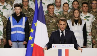 Präsident Macron steht hinter einem Rednerpult, hinter ihm die Landesfahne und Soldaten.