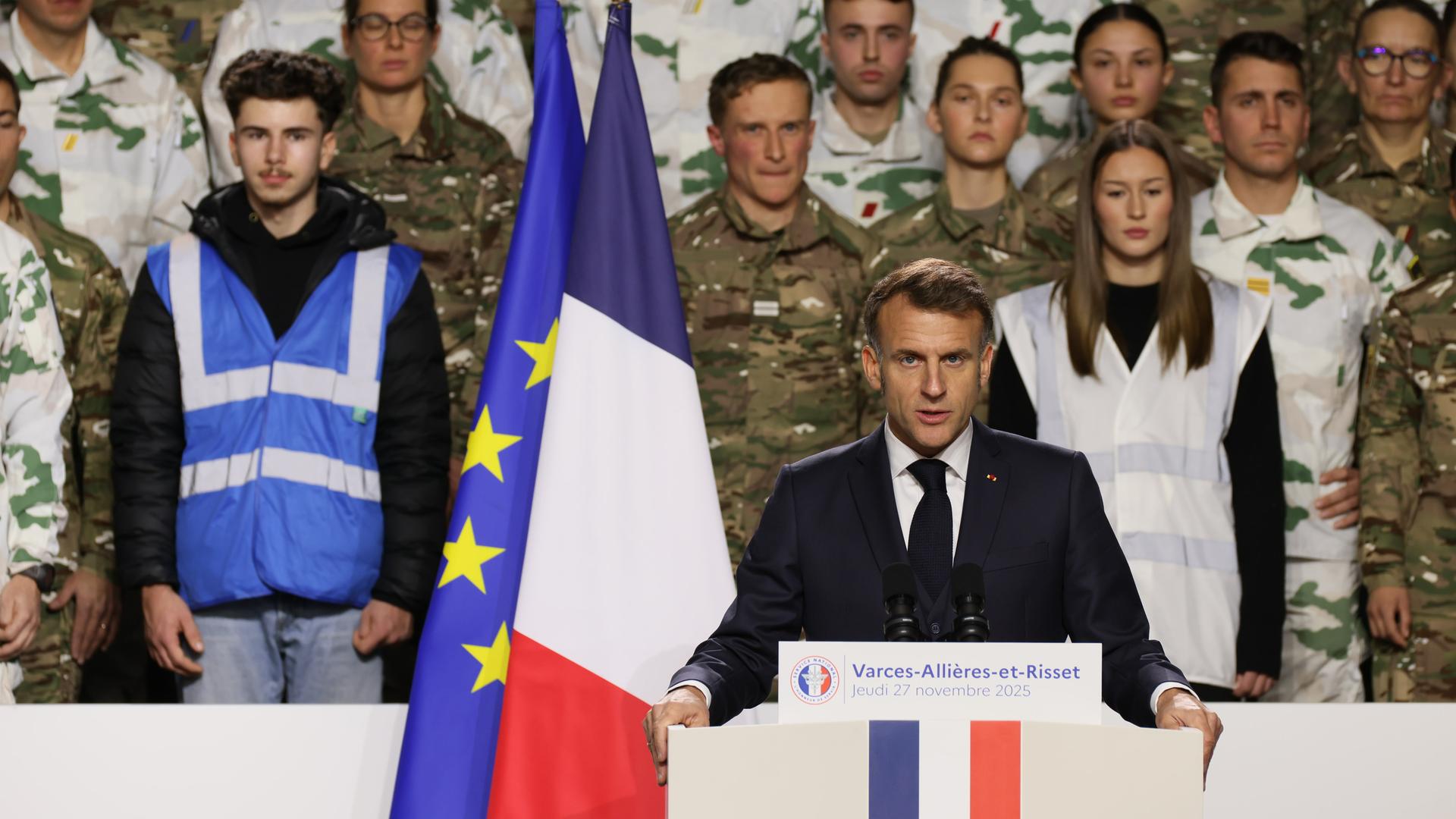 Präsident Macron steht hinter einem Rednerpult, hinter ihm die Landesfahne und Soldaten. Präsident Macron steht hinter einem Rednerpult, hinter ihm die Landesfahne und Soldaten.