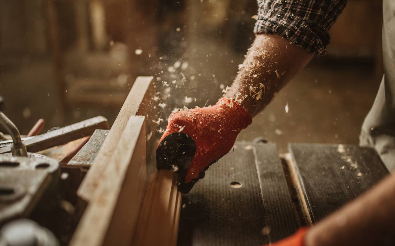 Ein Tischler arbeitet mit manuellem und elektrischem Werkzeug.
