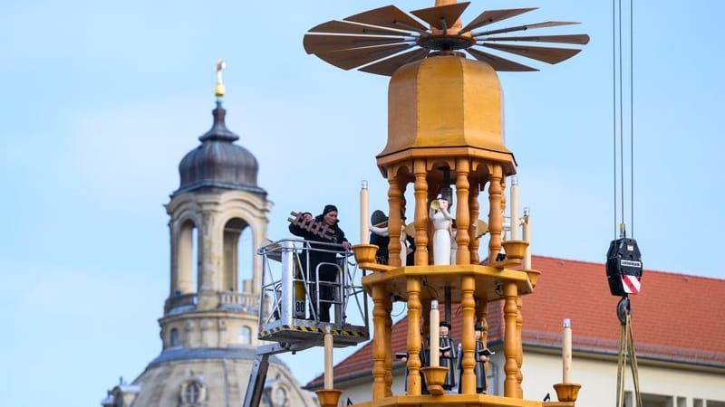 Handwerker montieren vor der Kulisse der Frauenkirche auf dem Altmarkt eine rund 15 Meter hohe erzgebirgische Weihnachtspyramide: Bereits am Freitag folgen dann die ersten Verkaufshütten. Handwerker montieren vor der Kulisse der Frauenkirche auf dem Altmarkt eine rund 15 Meter hohe erzgebirgische Weihnachtspyramide: Bereits am Freitag folgen dann die ersten Verkaufshütten.