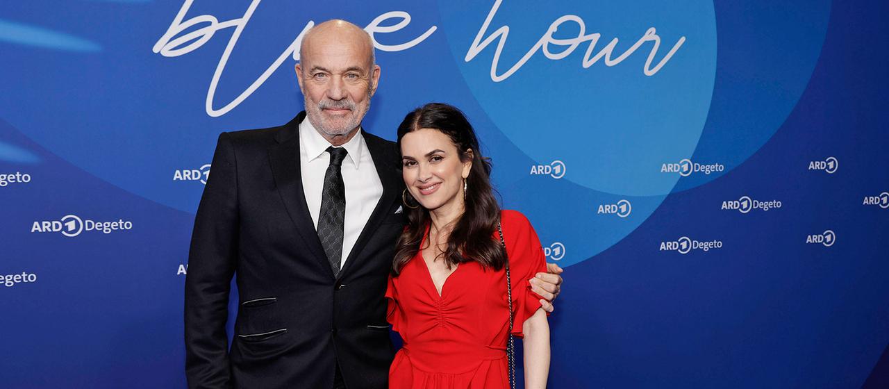 Heiner Lauterbach posiert mit seiner Frau Viktoria auf dem blauen Teppich.