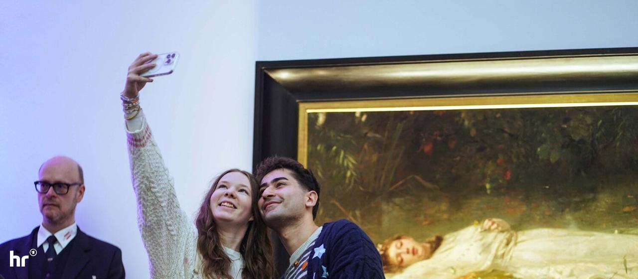 Zwei junge Leute machen ein Selfie vor dem Ophelia-Gemälde