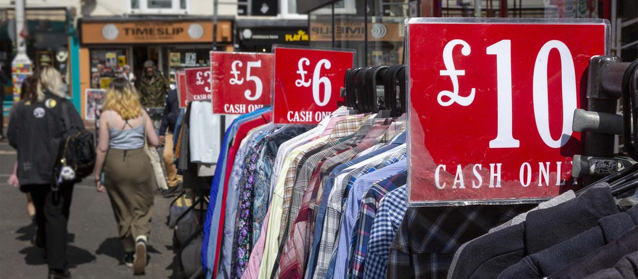 Preisschilder an Verkaufsständern für Bekleidung in Brighton, England. | picture alliance / Photononstop Preisschilder an Verkaufsständern für Bekleidung in Brighton, England.