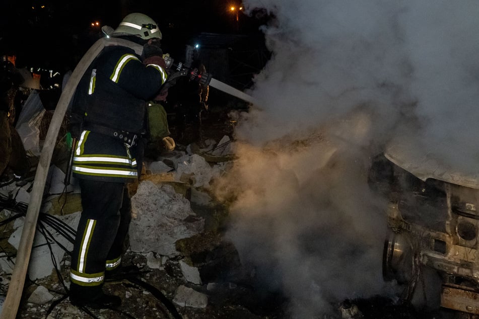Rettungskräfte löschen ein Feuer in einem durch einen russischen Angriff beschädigten Wohngebäude.