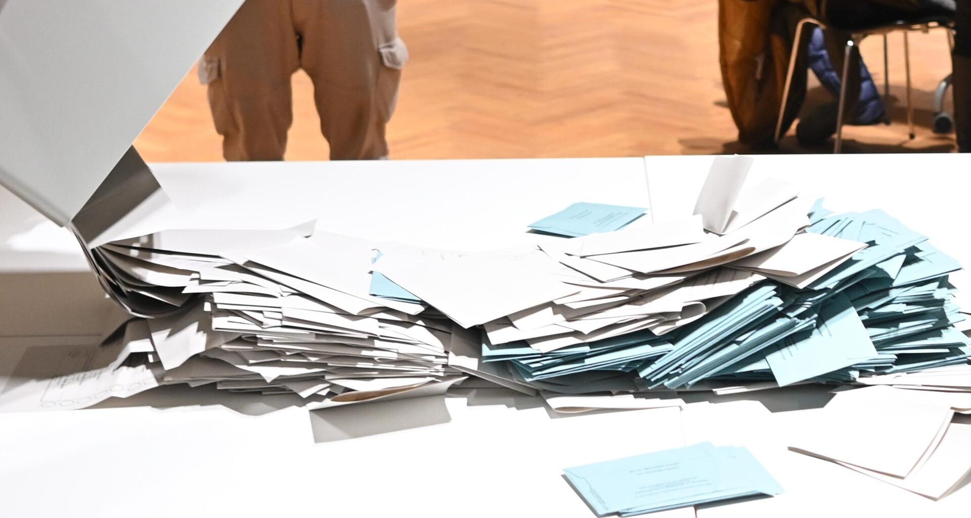 Stimmzettel werden in einem Wahlbüro bei der Wahl zum Kieler Oberbürgermeister zum Auszählen auf einem Tisch geschüttet.