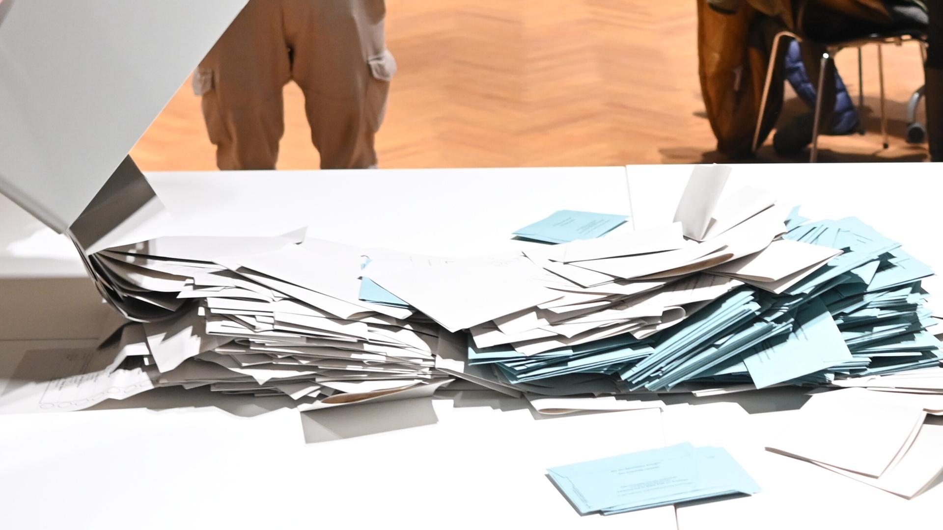 Stimmzettel werden in einem Wahlbüro bei der Wahl zum Kieler Oberbürgermeister zum Auszählen auf einem Tisch geschüttet.