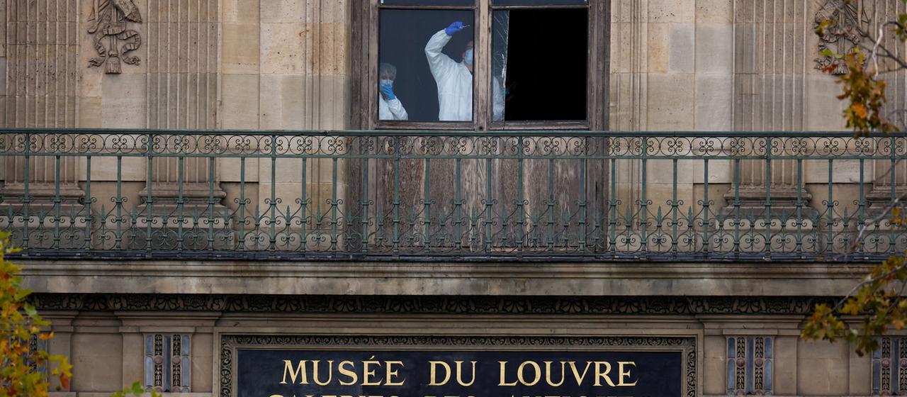 Mitarbeiter der Spurensicherung sind hinter einem Fenster des Louvre zu sehen. | REUTERS Mitarbeiter der Spurensicherung sind hinter einem Fenster des Louvre zu sehen.