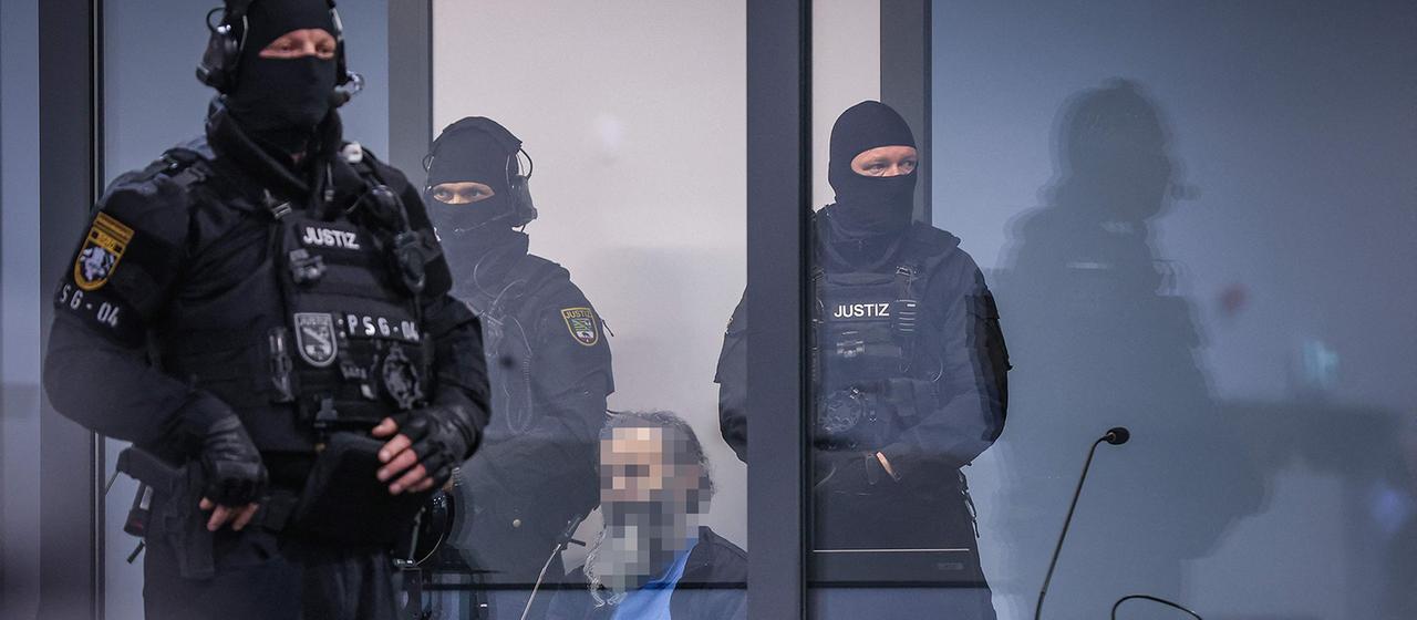 Der Angeklagte sitzt in einer kugelsicheren Glasbox beim Prozess in Magdeburg. | AFP Der Angeklagte sitzt in einer kugelsicheren Glasbox beim Prozess in Magdeburg.