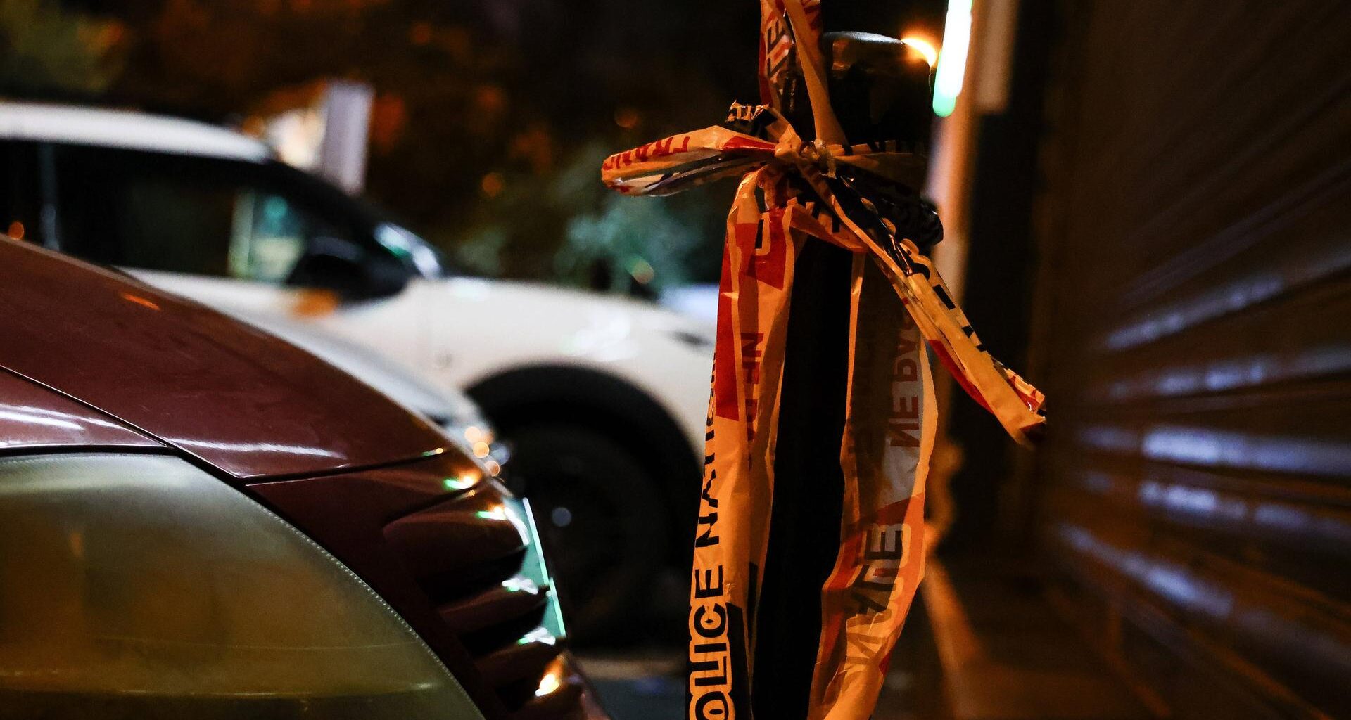 Ein Flatterband der französischen Polizei hängt an einem Straßenpoller.