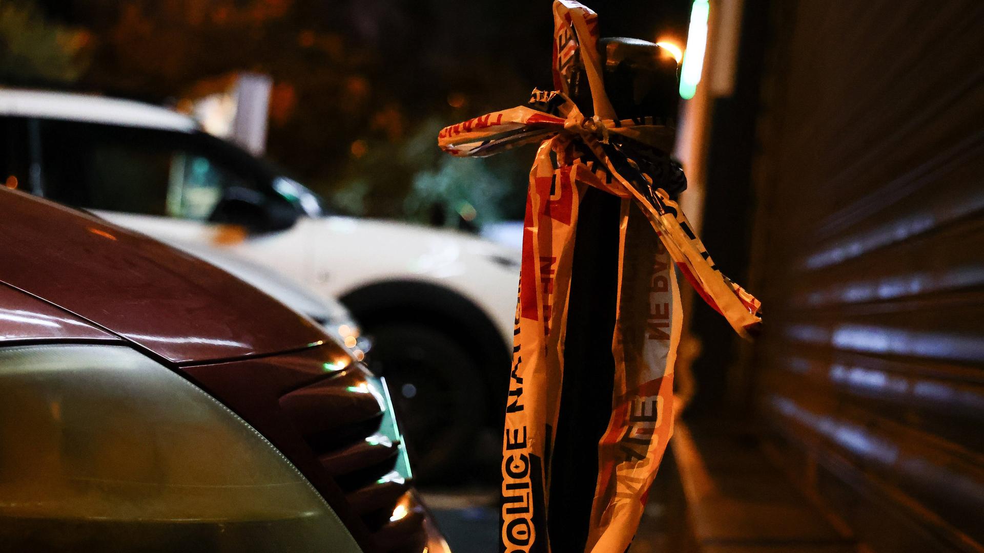Ein Flatterband der französischen Polizei hängt an einem Straßenpoller. Ein Flatterband der französischen Polizei hängt an einem Straßenpoller.