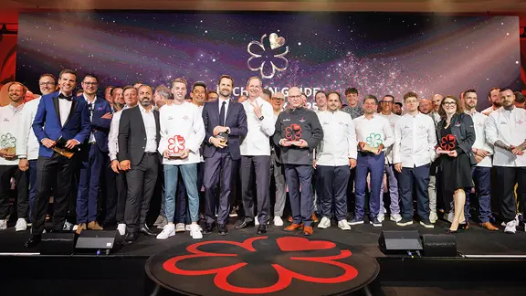 Die Preisträger der Verleihung der Guide-Michelin-Sterne 2025 für deutsche Restaurants stehen bei einem Gruppenbild zusammen.