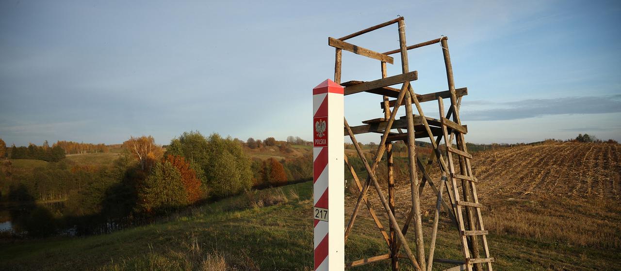 Ein polnischer Grenzpfosten steht neben einem Hochsitz an der Suwalki-Lücke.