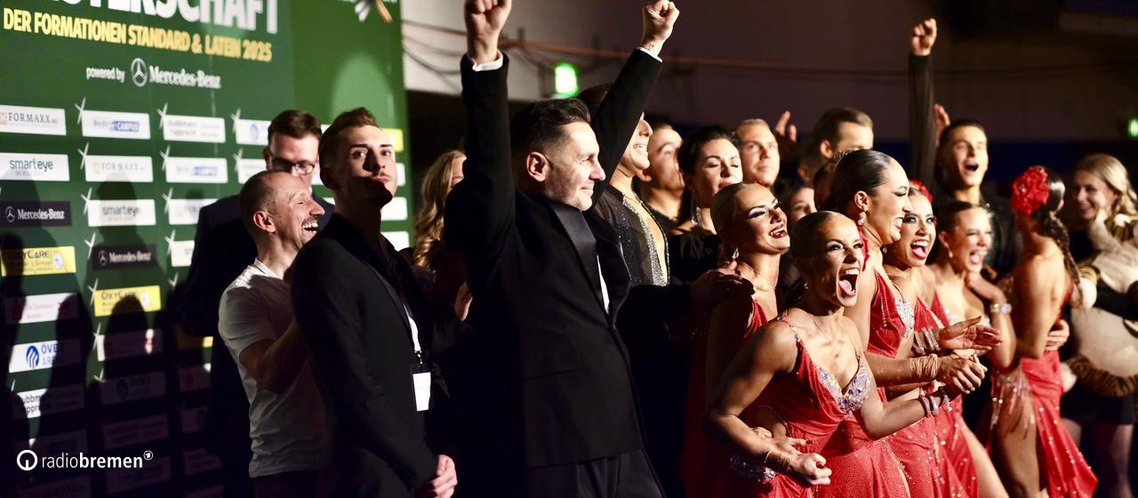 Die Lateinformation des Bremer Grün-Gold-Clubs jubelt mit Trainer Roberto Albanese, als der Sieg bei der Deutschen Meisterschaft feststeht. | Waldemar Quella Die Lateinformation des Bremer Grün-Gold-Clubs jubelt mit Trainer Roberto Albanese, als der Sieg bei der Deutschen Meisterschaft feststeht.