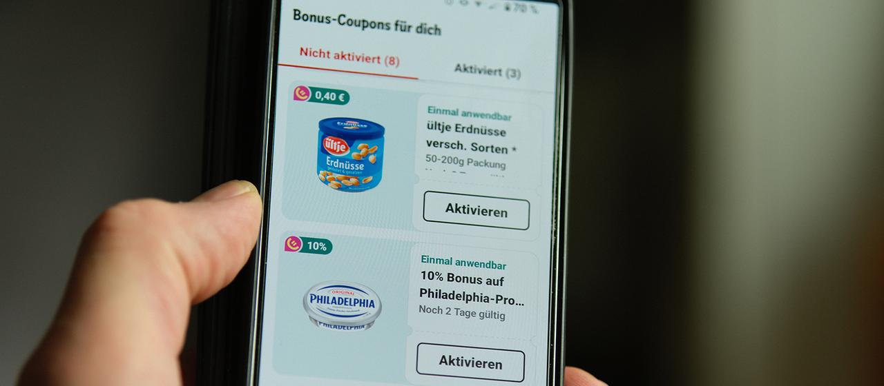 Auf dem Bildschirm eines Smartphones ist die REWE-App mit dem Bonus-Bereich geöffnet. | dpa Auf dem Bildschirm eines Smartphones ist die REWE-App mit dem Bonus-Bereich geöffnet.