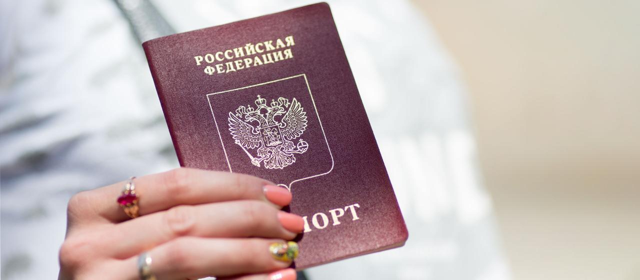 Eine Frau hält einen russischen Pass.