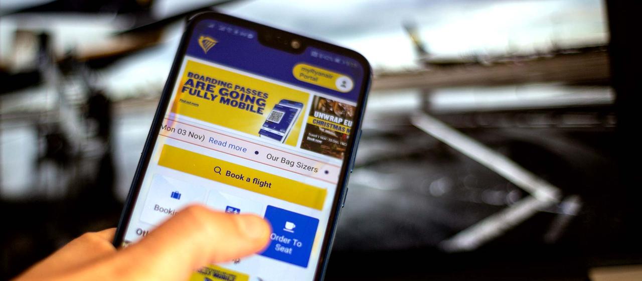 Ticketbuchung am Smartphone mit der Ryanair App. | picture alliance / NurPhoto Ticketbuchung am Smartphone mit der Ryanair App.