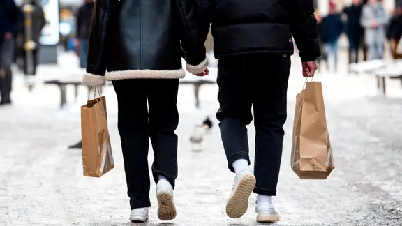 Eine Frau und ein Mann tragen Einkaufstüten.