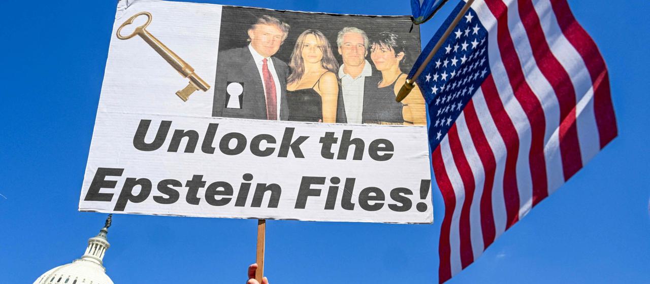 Ein Demonstrant hält ein Plakat mit einem Bild von Donald Trump und Jeffrey Epstein in die Höhe, mit dem die Herausgabe der Akten gefordert wird.