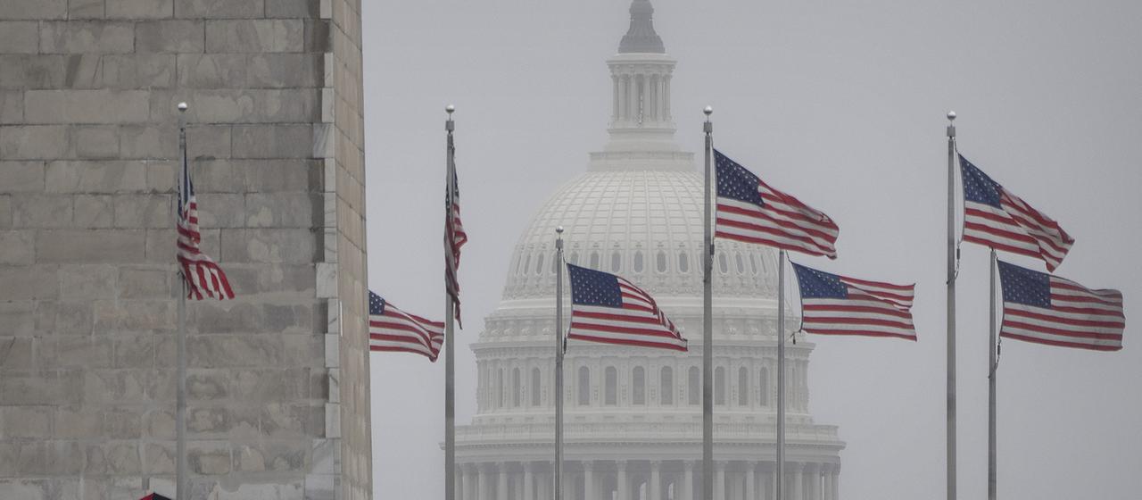 Vor dem US-Kapitol sind wehende USA-Fahnen zu sehen.