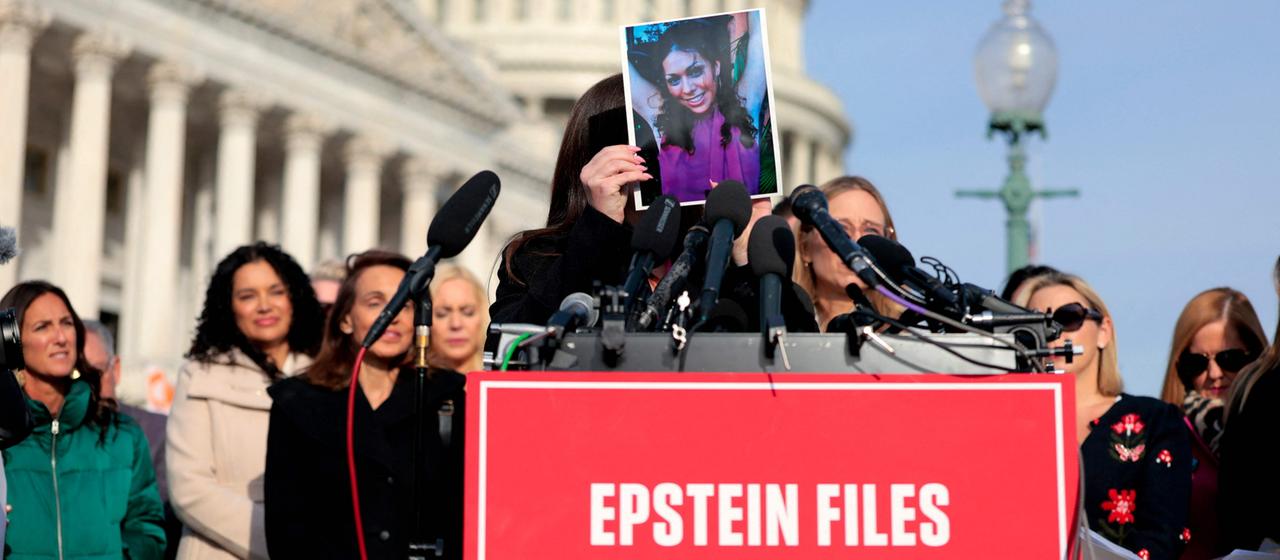 Vor dem Kapitol in Washington hält eine Frau, ein früheres Missbrauchsopfer Epsteins, ein Foto von sich vor ihr Gesicht.