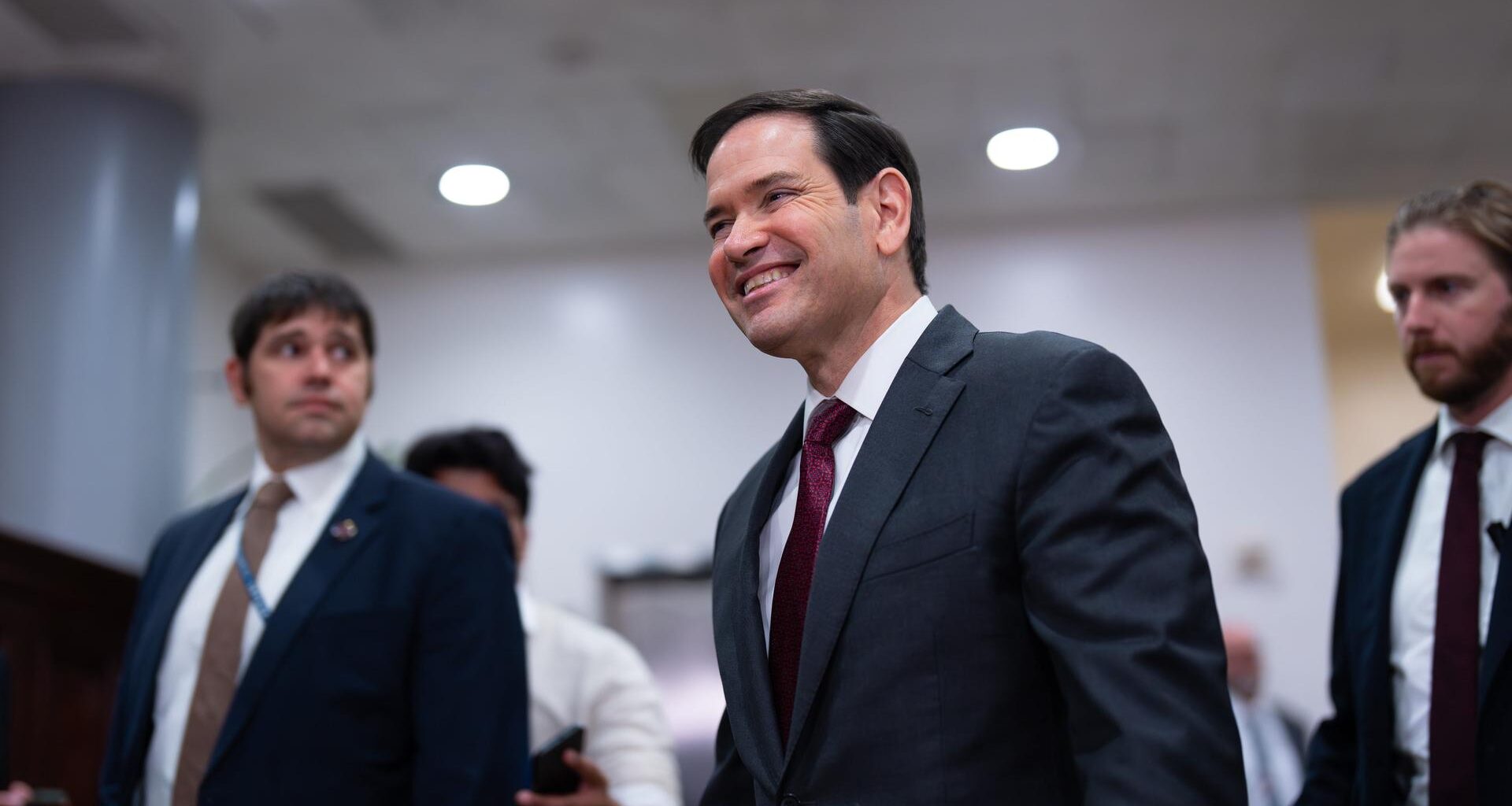 US-Außenminister Marco Rubio wird von zwei Personen begleitet.