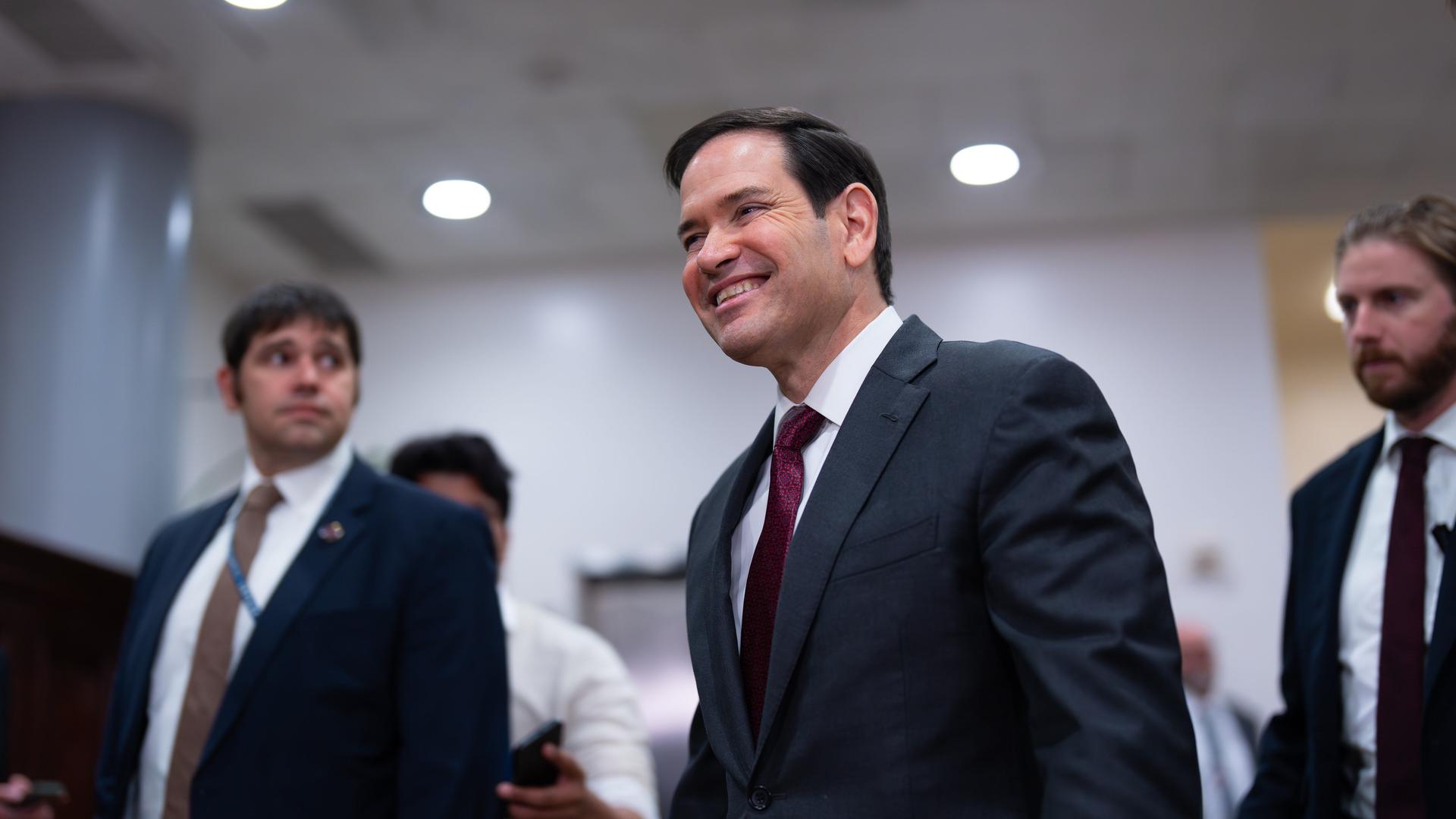 US-Außenminister Marco Rubio wird von zwei Personen begleitet. US-Außenminister Marco Rubio wird von zwei Personen begleitet.