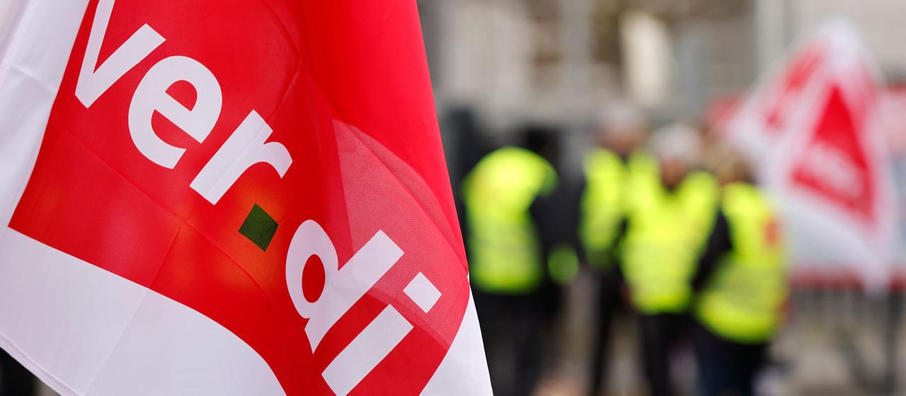 Fahne mit dem Logo der Verdi bei einer Kundgebung. | picture alliance / Panama Pictur Fahne mit dem Logo der Verdi bei einer Kundgebung.