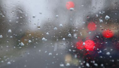 Graupelkörner und Regentropfen auf einer Windschutzscheibe. Kommende Woche muss mit nasskaltem Wetter gerechnet werden