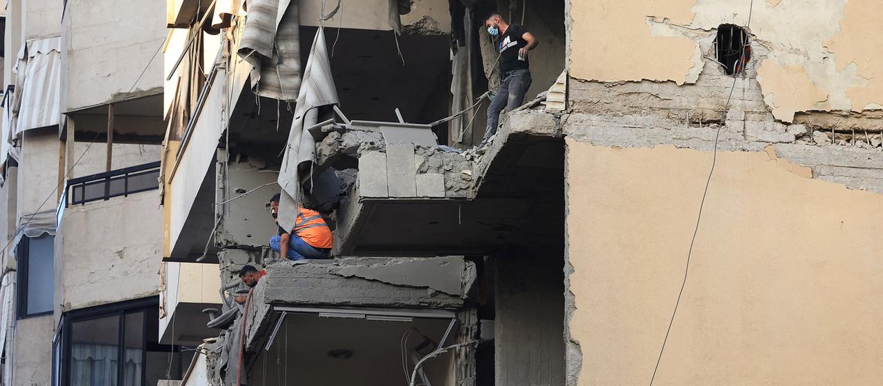 Zwei Männer begutachten massive Schäden an einem Wohnhaus. | REUTERS Zwei Männer begutachten massive Schäden an einem Wohnhaus.