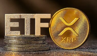 Goldmünzen, gestapelt neben großen Buchstaben mit der Aufschrift ETF und einer Goldmünze mit dem Logo der Kryptowährung Ripple (XRP).