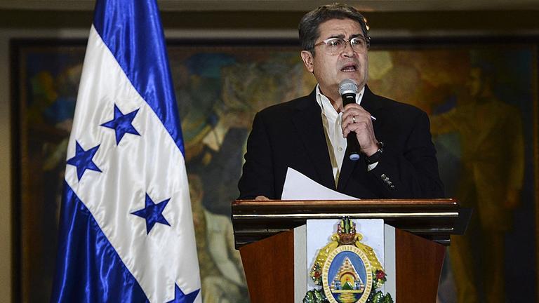 Porträt von Juan Orlando Hernández am Rednerpult.