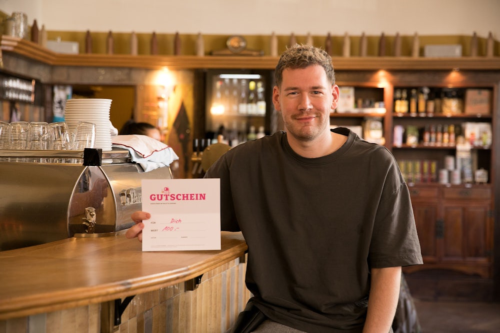 Max Thissen, Betriebsleiter vom Saletta, präsentiert den 100-Euro-Gutschein, den man in dem Giesinger Wirtshaus aktuell für 85 Euro bekommt.