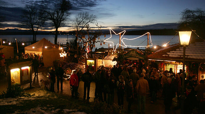 Ausflügler besuchen am zweiten Advent-Sonntag bei Abenddämmerung den Christkindlmarkt auf der Fraueninsel im Chiemsee (Archiv). Ausflügler besuchen am zweiten Advent-Sonntag bei Abenddämmerung den Christkindlmarkt auf der Fraueninsel im Chiemsee (Archiv).