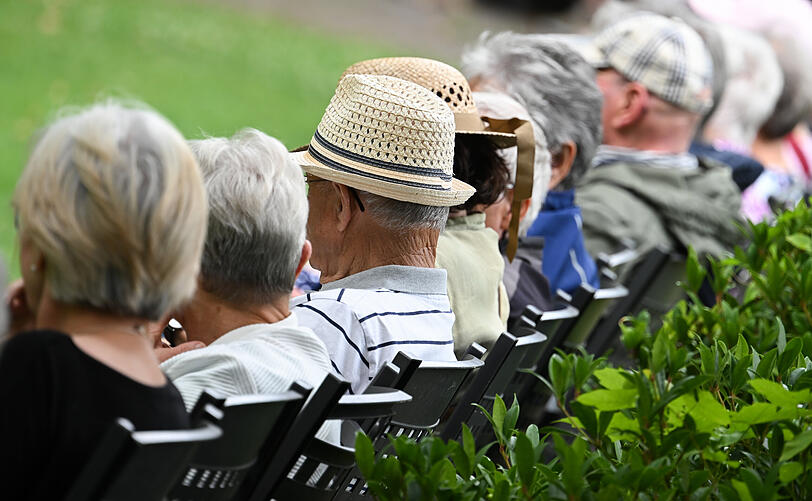 Ältere Menschen sitzen nebeneinander während eines Konzertbesuches.