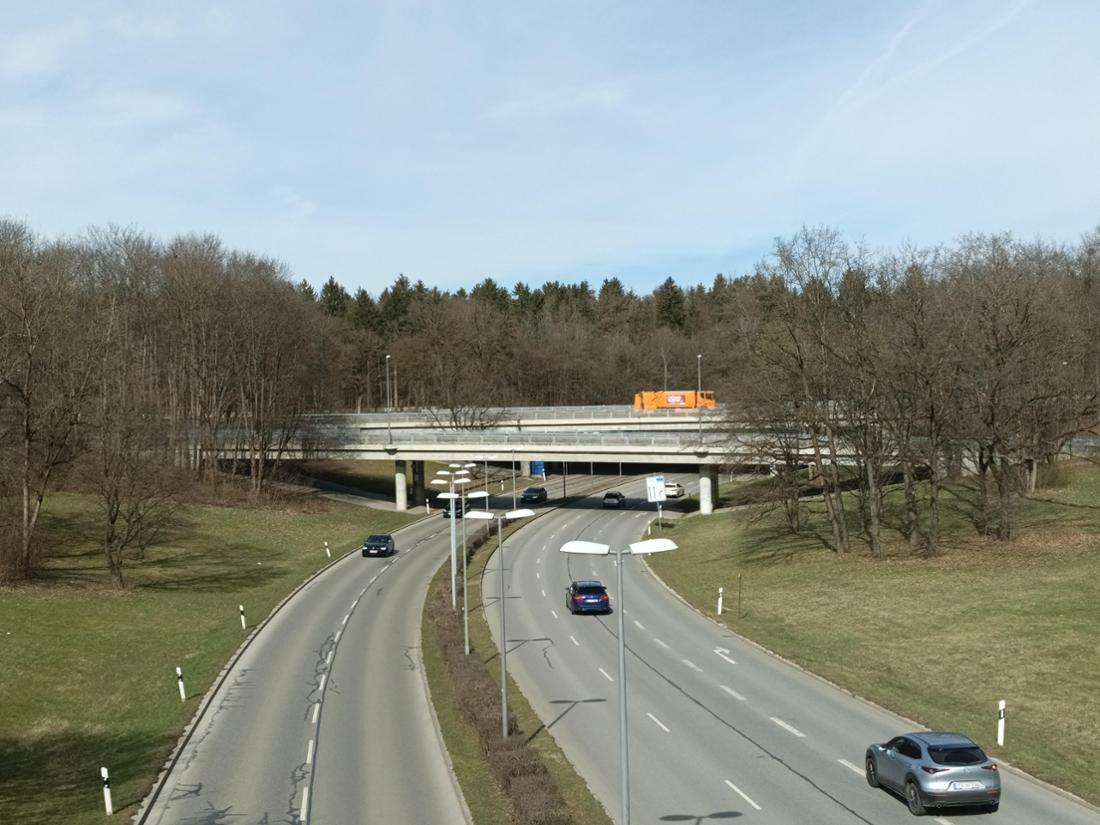 Eine Brücke über eine befahrene Straße an der A95 bei München. 