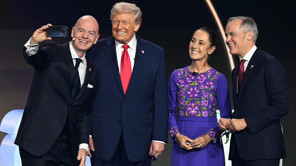 Verhältnis zu Donald Trump: Gianni Infantino (links) macht bei der WM-Auslosung ein Selfie mit Donald Trump, Mexikos Präsidentin Claudia Sheinbaum und Kanadas Premierminister Mark Carney (von links nach rechts).