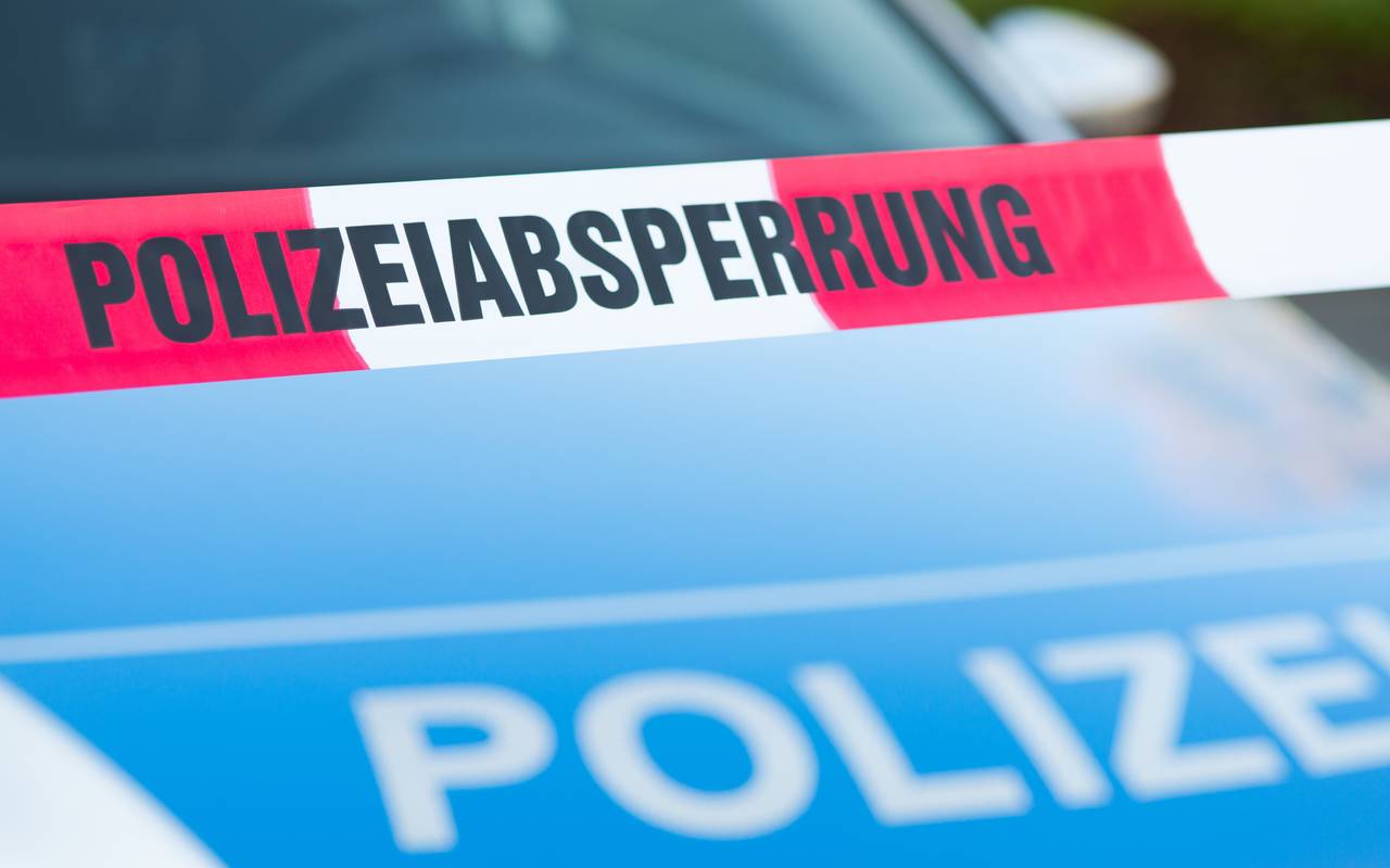 Absperrband vor einem Polizeiauto.