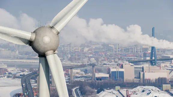 Ein Windrad steht vor dem Hamburger Hafen.