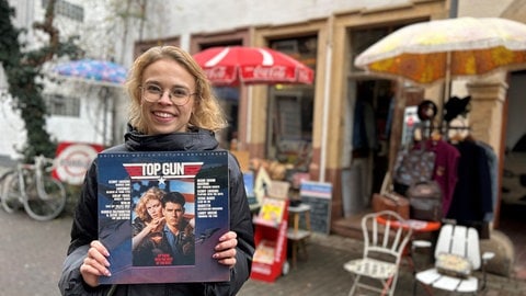 SWR-Reporterin Theresa Linnen hält eine Schallplatte mit der Filmmusik von Top Gun hoch.
