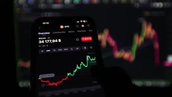 Ein Handy mit einer Anlage in Krypto-Währung auf dem Display.