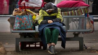 Symbolbild: Eine aeltere Obdachlose sitzt mit ihren Habseligkeiten in diversen Taschen auf einer Bank. (Quelle: dpa/Steinberg)