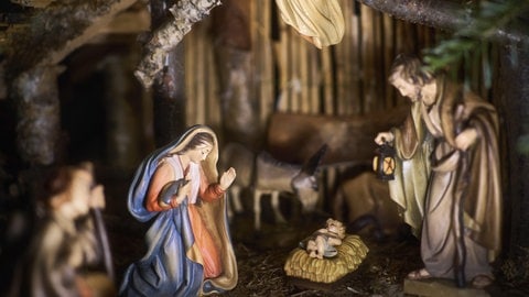 Klassische Krippe mit der Heiligen Familie in einem rustikalen Holzstall. 
