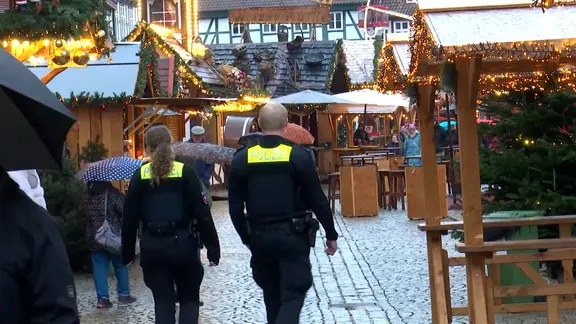 Polizisten gehen nach dem Anschlag in Magdeburg auf dem Weihnachtsmarkt in Celle Streife.