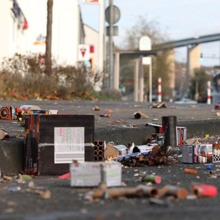Reste von Feuerwerk an Silvester liegen auf der Straße. In Baden-Württemberg startet der Verkauf von Böllern, Raketen & Co. Einige Menschen fordern ein Böllerverbot.