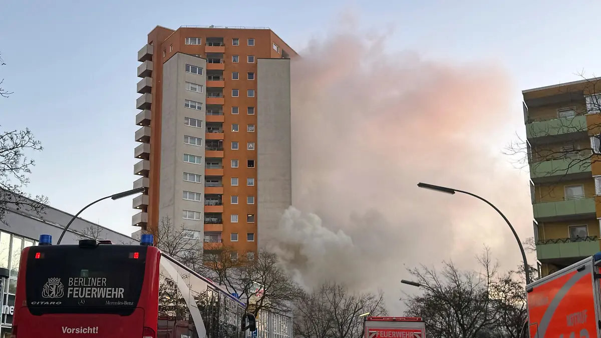 Rettungskräften vor dem brennenden Hochhaus in Berlin-Spandau.