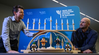 Kunsthandwerker Ringo Müller und der Gestalter Markus Weber präsentieren ihre Schwibbogen-Chanukkia. Zum Auftakt des Jahres der jüdischen Kultur in Sachsen wird die erste Kerze erleuchtet. 