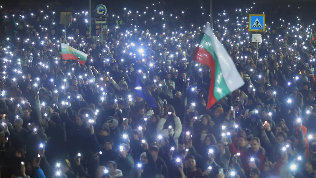 18-12-2025-Bulgarien-Sofia-Demonstranten-halten-Fahnen-und-singen-die-Nationalhymne-waehrend-zehntausende-Menschen-die-Strassen-der-Hauptstadt-und-anderer-Grossstaedte-Bulgariens-fuellen-und-faire-Wahlen-und-eine-unabhaengige-Justiz-fordern-die-in-der-Lage-ist-die-weit-verbreitete-Korruption-wirksam-zu-bekaempfen