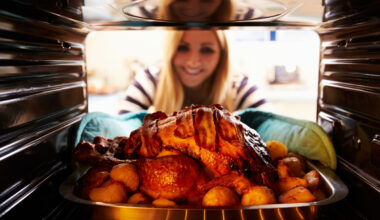 Eine Frau nimmt einen gebratenen Truthahn aus dem Backofen.