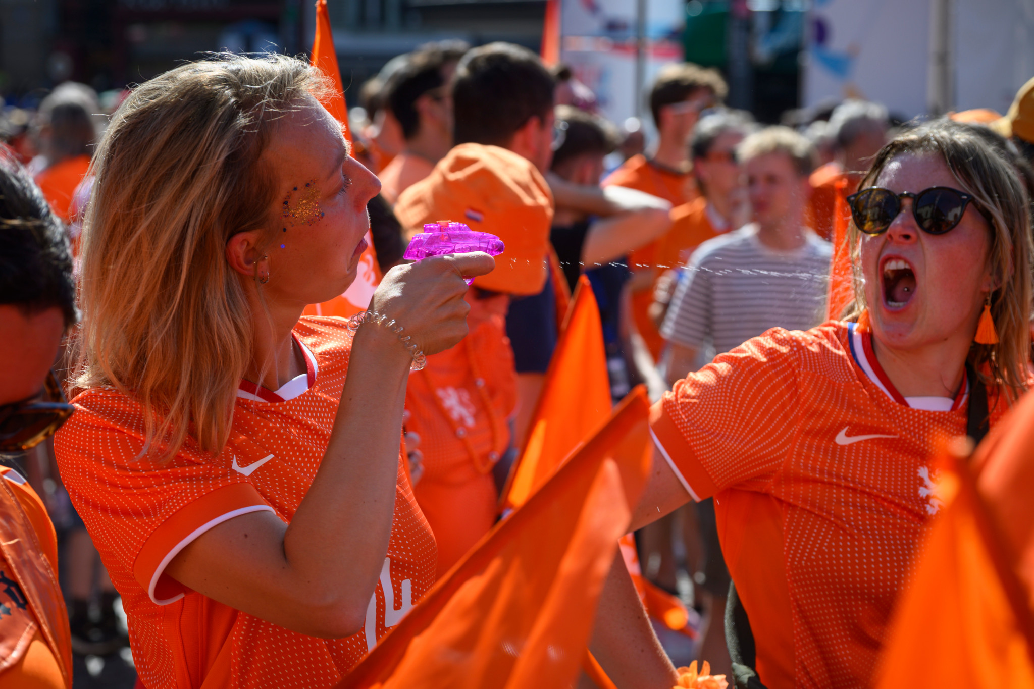 Fans der EURO Holland Frankreich in orangefarbenen Trikots feiern auf dem Barfüsserplatz in Basel.